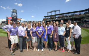 DPS Foundation and Rockies staff join on the field to celebrate the Rockies check presentation in July 2015