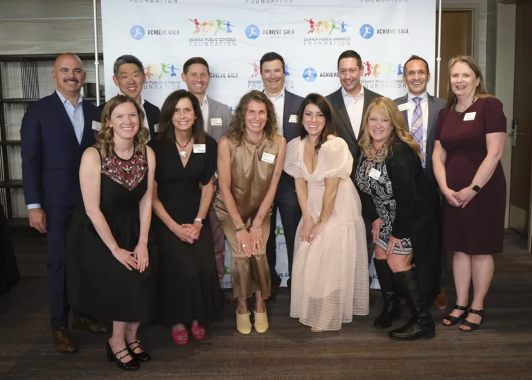 Members of the DPS Foundation board pose with Sara Hazel, CEO of the DPS Foundation in front of a backdrop at the 2024 Achieve Gala.