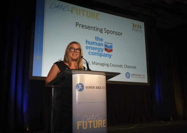 A representative from Chevron presenting behind a podium on stage at the Achieve Gala.