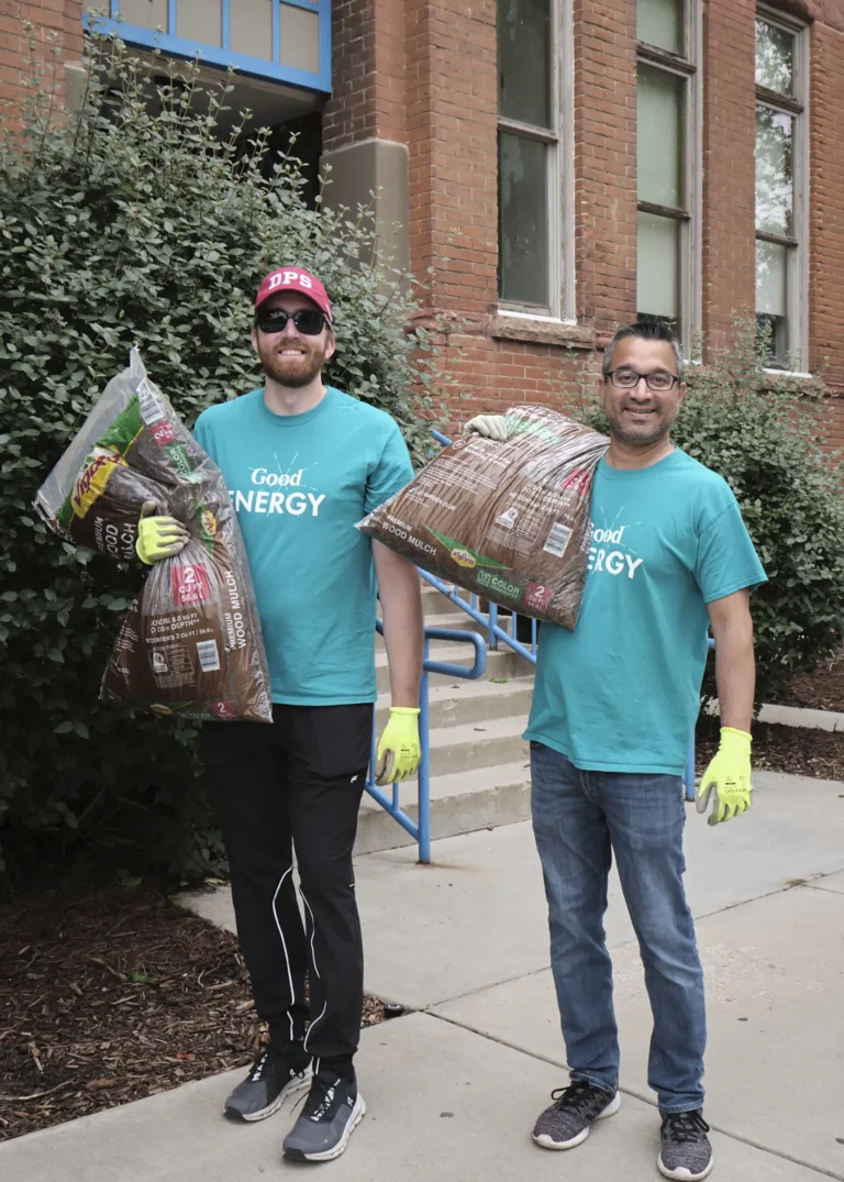 A group of volunteers carry large bags of mulch to a school for the Back to Class Bash.