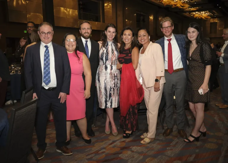 A group in formal attire in the ballroom of the Achieve Gala.