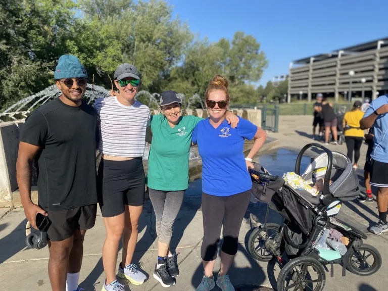 Runners at a 5k, one of them holding a stroller with a baby inside