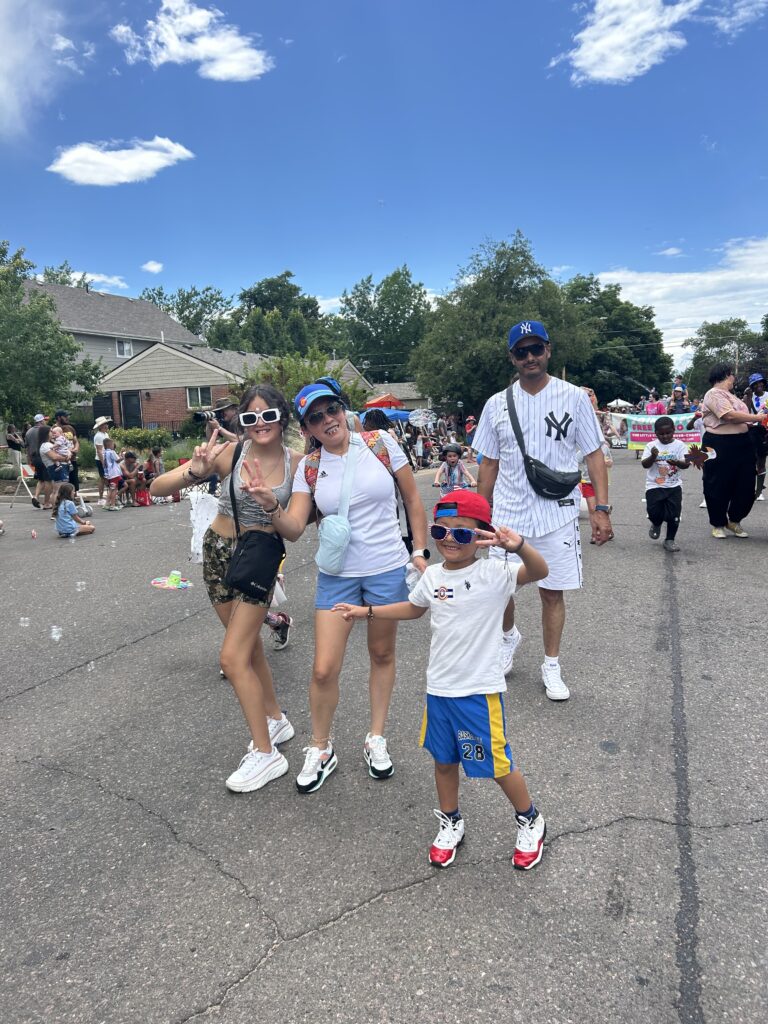 A family walking together down a street during a community parade.