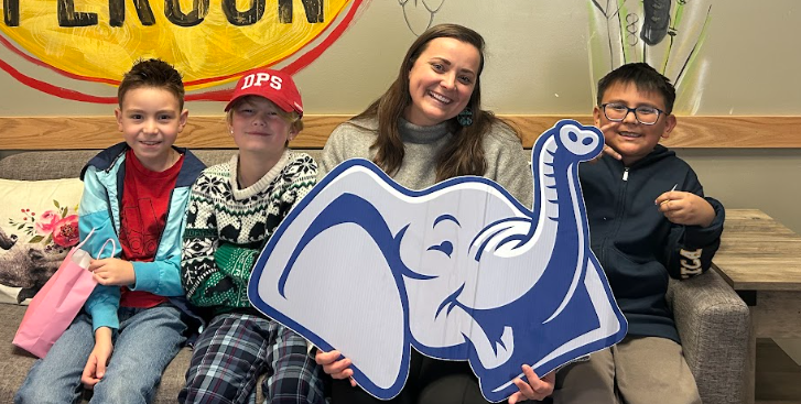 Denver Public Schools students posing in front of a colorful “Be a Good Person” mural.
