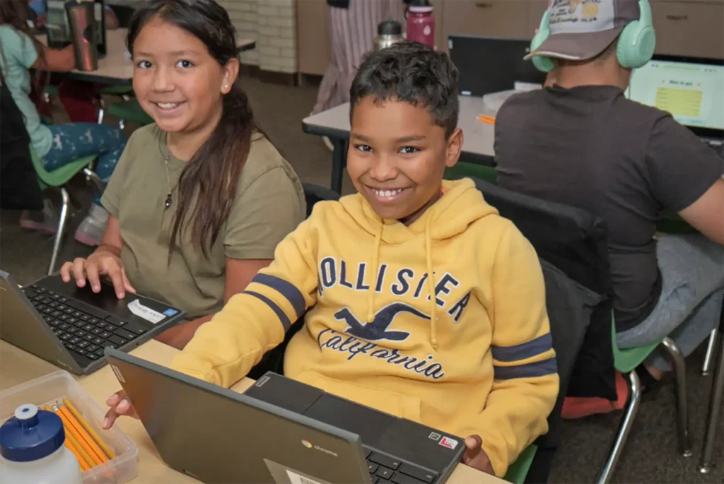 Two DPS students working on laptops