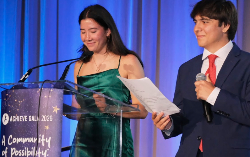 Two student emcees speaking on stage at Achieve Gala 2026